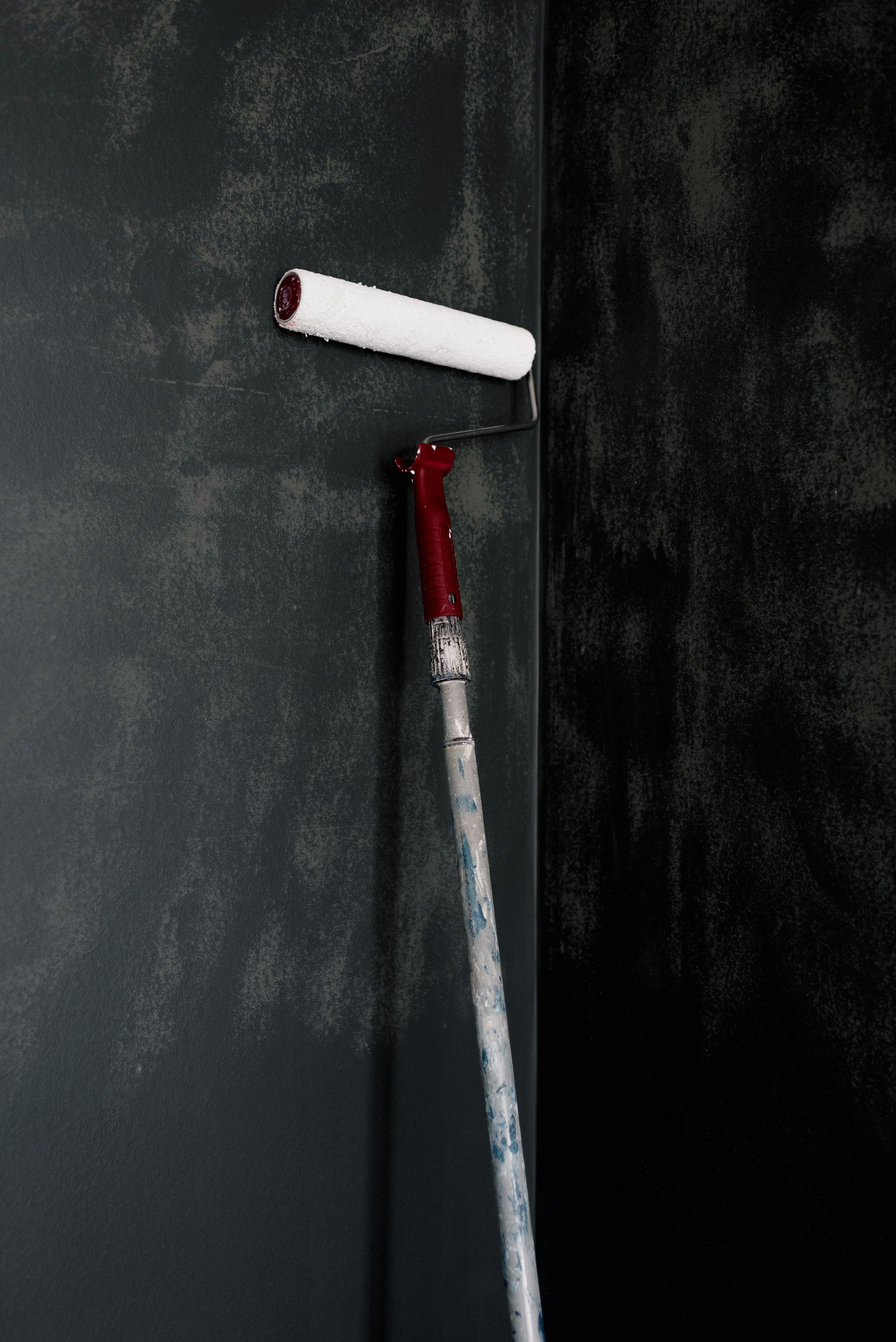 A paint roller resting against a dark wall